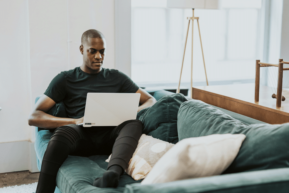 man sitting on a green sofa as he makes money as a brand ambassador